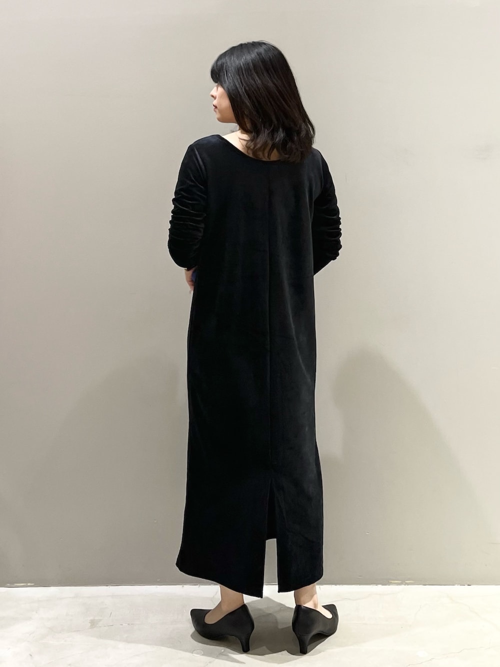 ブラック系のワンピース、ブルー系のショルダーバッグ、ブラック系のパンプスを着用したレディースの冬コーディネートの3枚目の写真