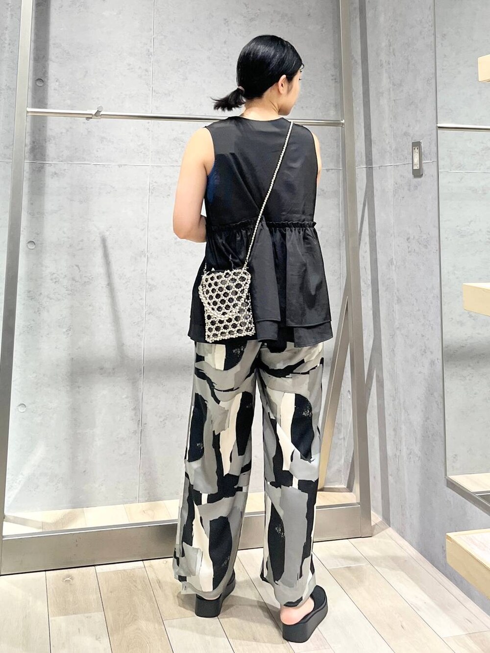 ブルー系のTシャツ/カットソー、ブラック系のサンダル、ブラック系のベストを着用したレディースの夏コーディネートの3枚目の写真