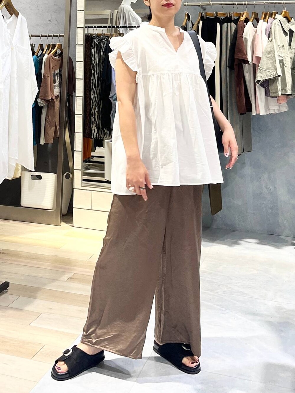 ブラック系のサンダル、ブラウン系のその他パンツ、ブラック系のショルダーバッグを着用したレディースの夏コーディネートの6枚目の写真