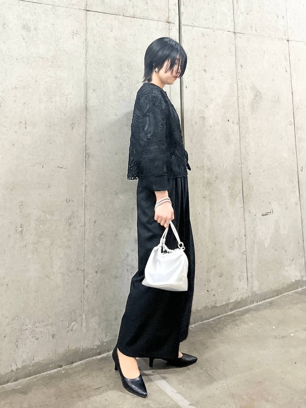シルバー系のショルダーバッグ、ブラック系のシャツ/ブラウス、ブラック系のパンプスを着用したレディースの春コーディネートの3枚目の写真
