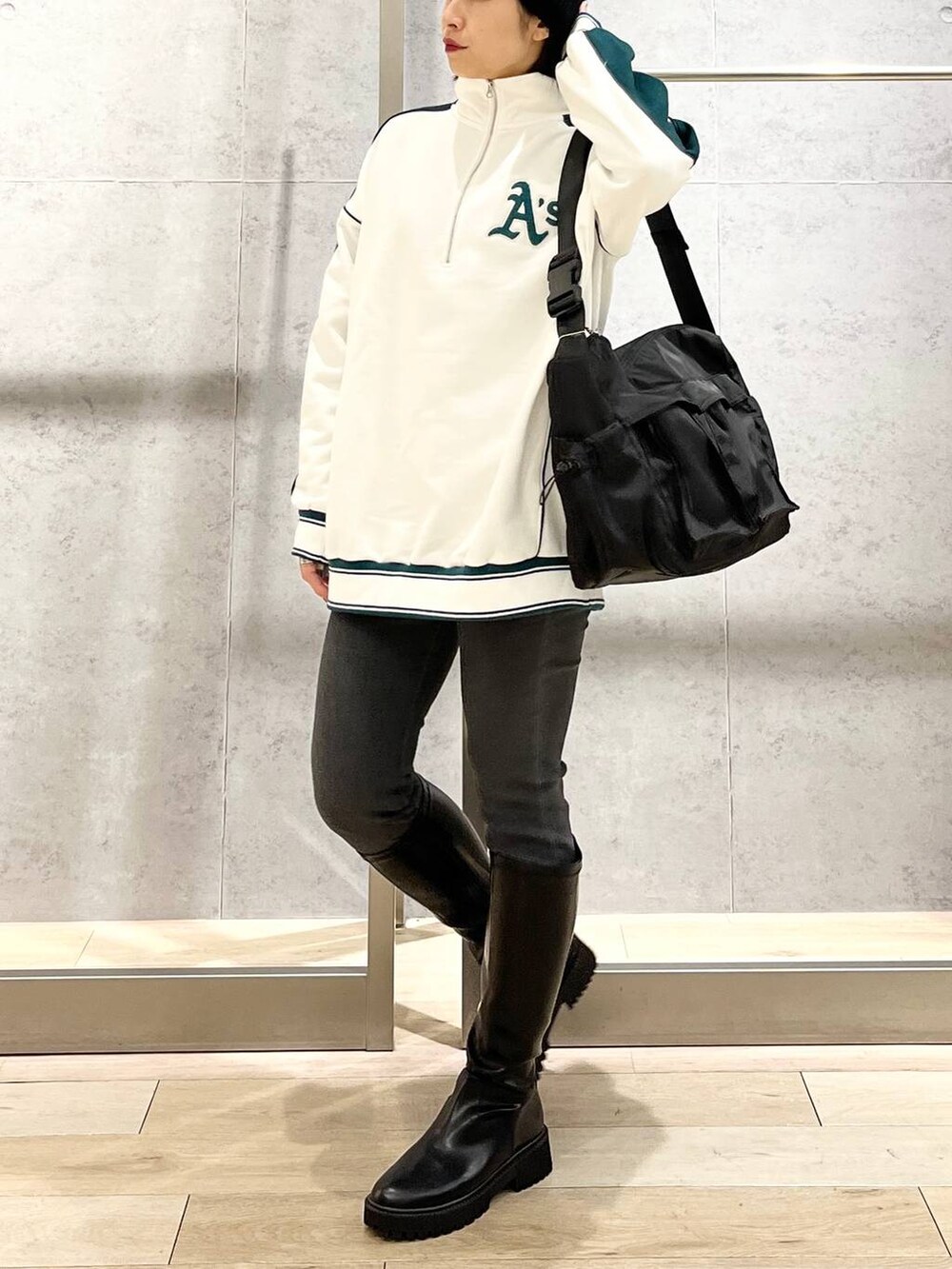 ホワイト系のTシャツ/カットソー、ブラック系のブーツ、グレー系のデニムパンツを着用したレディースの冬コーディネートの3枚目の写真