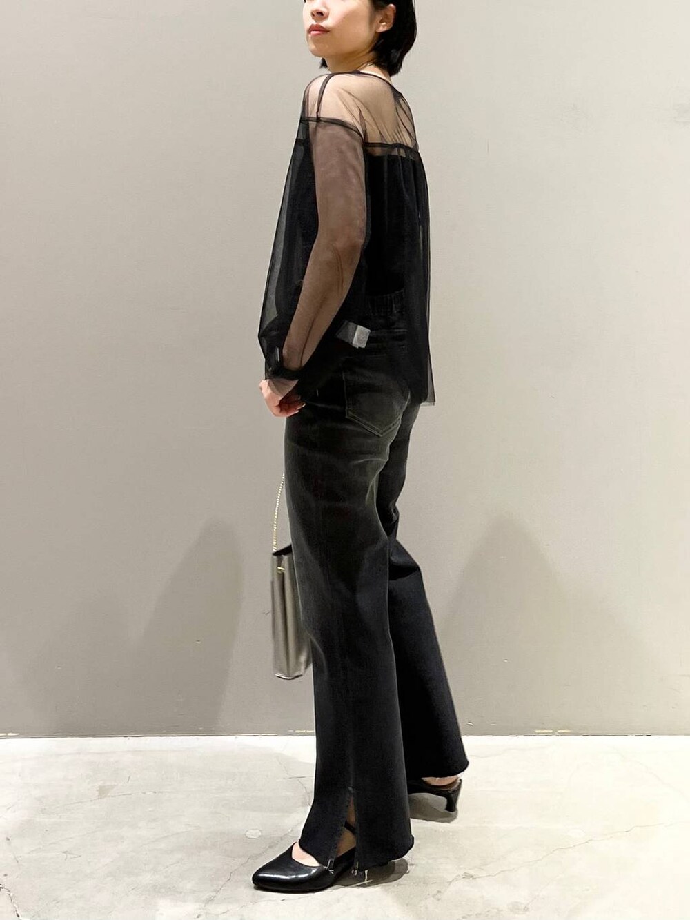 ブラック系のチューブトップ、ブラック系のTシャツ/カットソー、ブラック系のデニムパンツを着用したレディースの秋コーディネートの7枚目の写真