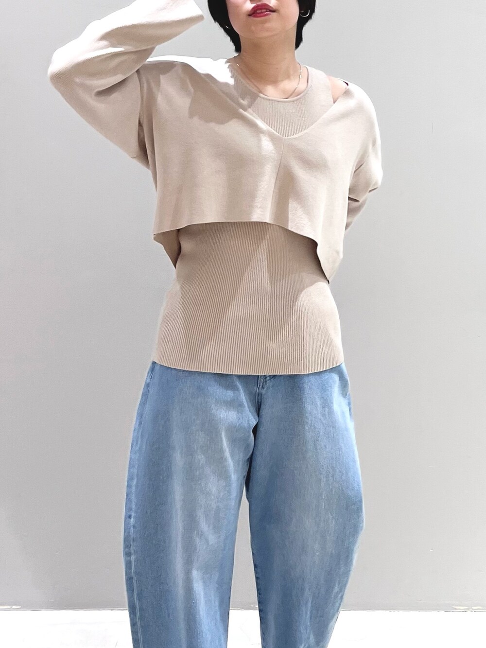 ブルー系のデニムパンツ、ブラック系のシューズ、ベージュ系のニット/セーターを着用したレディースの春コーディネートの6枚目の写真