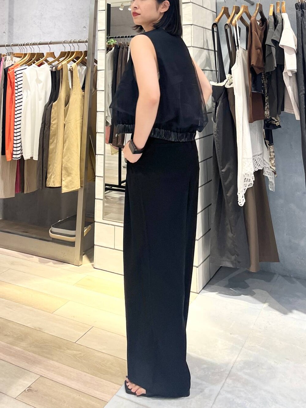 ホワイト系のタンクトップ、ブラック系のその他パンツ、オレンジ系のショルダーバッグを着用したレディースの夏コーディネートの6枚目の写真