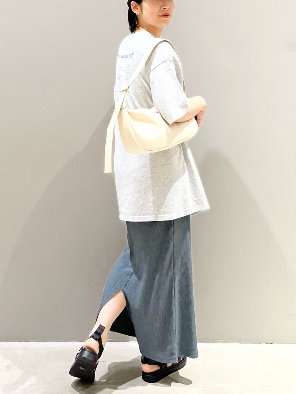 ホワイト系のショルダーバッグ、グリーン系のスカート、ブラック系のシューズを着用したレディースの夏コーディネートの6枚目の写真