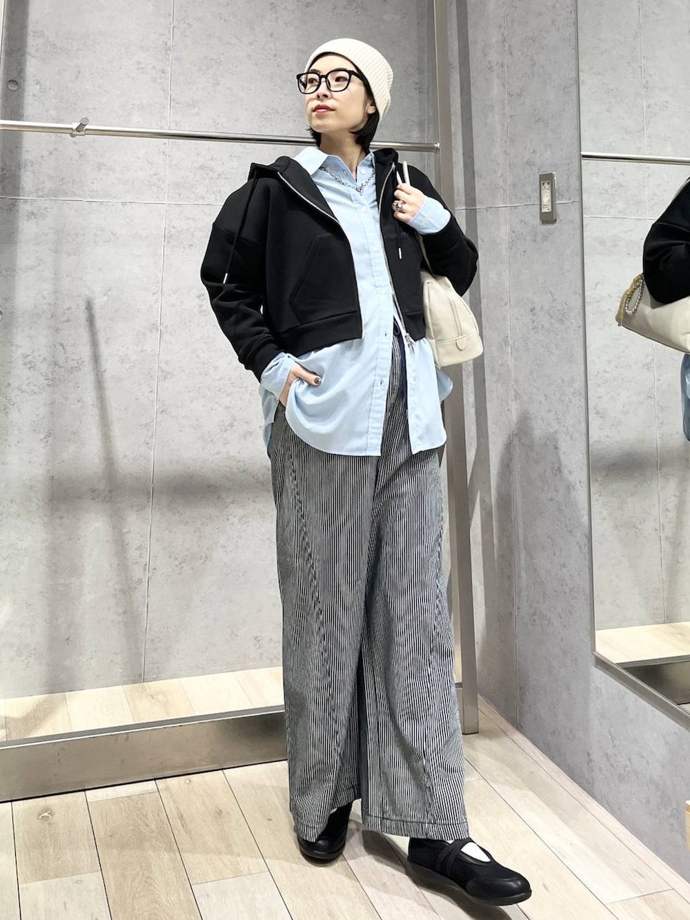 ブルー系のシャツ/ブラウス、ブラック系のボストンバッグ、ブラック系のパンプスを着用したレディースの冬コーディネートの4枚目の写真