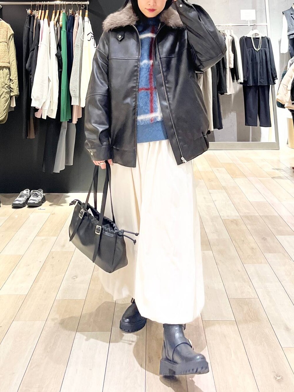 ブラック系のTシャツ/カットソー、ブラック系のブーツ、ブラック系のショルダーバッグを着用したレディースの冬コーディネートの3枚目の写真