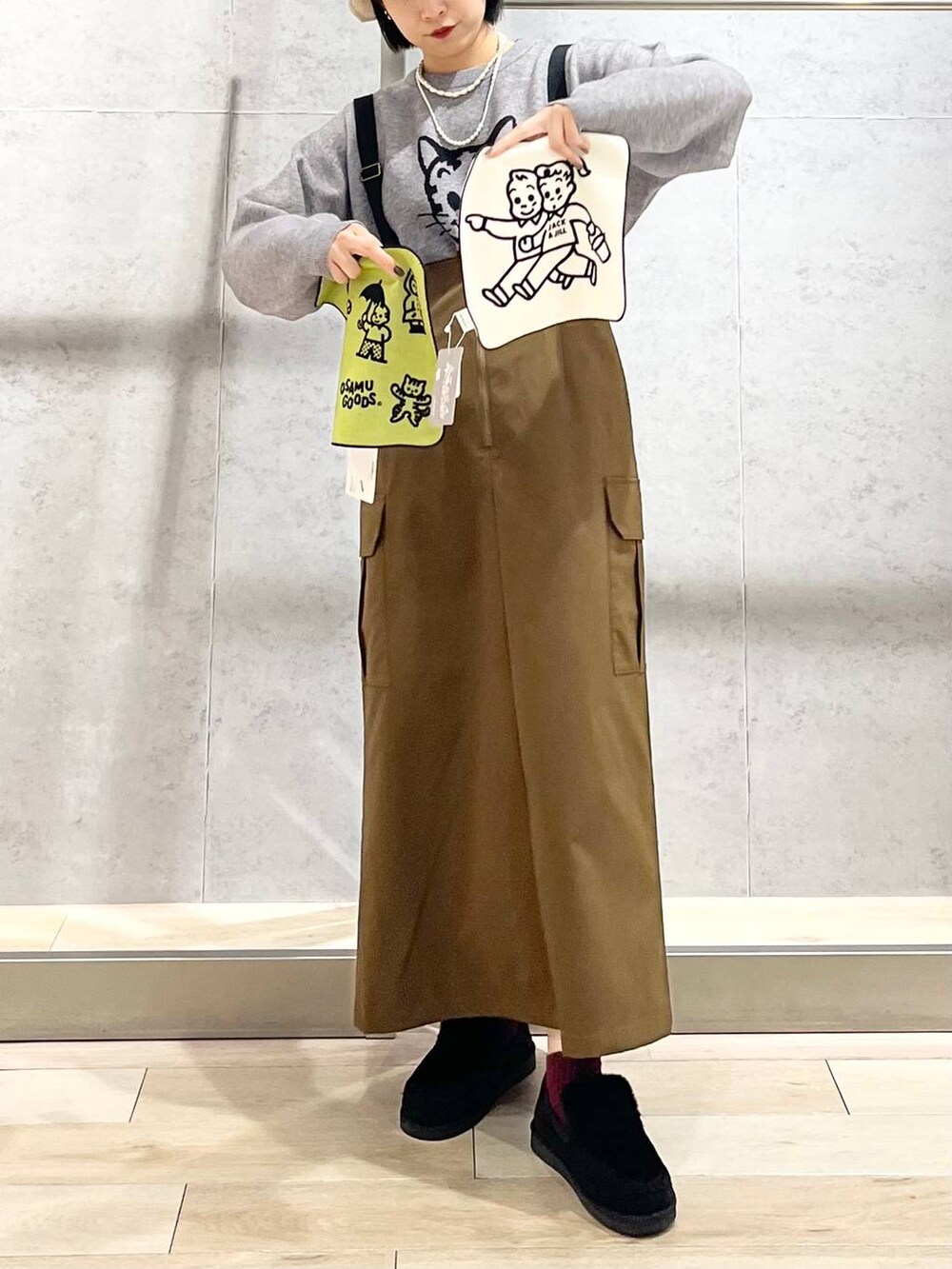 ブラック系のモカシン/デッキシューズ、ブラウン系のスカート、グレー系のニット/セーターを着用したレディースの冬コーディネートの3枚目の写真