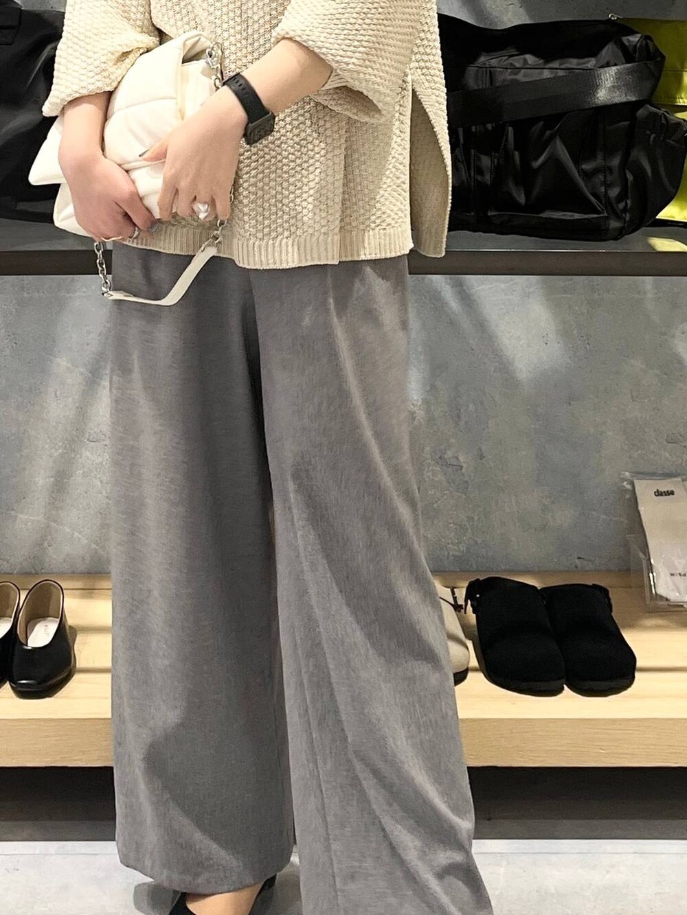 ホワイト系のショルダーバッグ、ホワイト系のニット/セーター、グレー系のスラックスを着用したレディースの春コーディネートの8枚目の写真