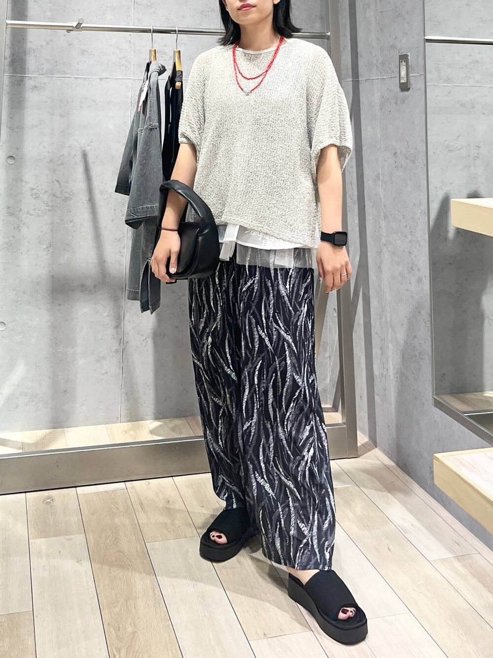 ブラック系のその他パンツ、ベージュ系のニット/セーター、ブラック系のサンダルを着用したレディースの夏コーディネートの4枚目の写真