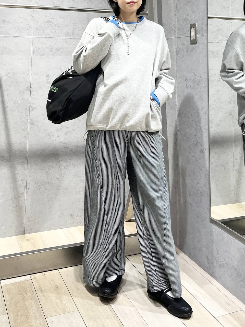 ブラック系のパンプス、ブラック系のトートバッグ、グレー系のTシャツ/カットソーを着用したレディースの冬コーディネートの2枚目の写真