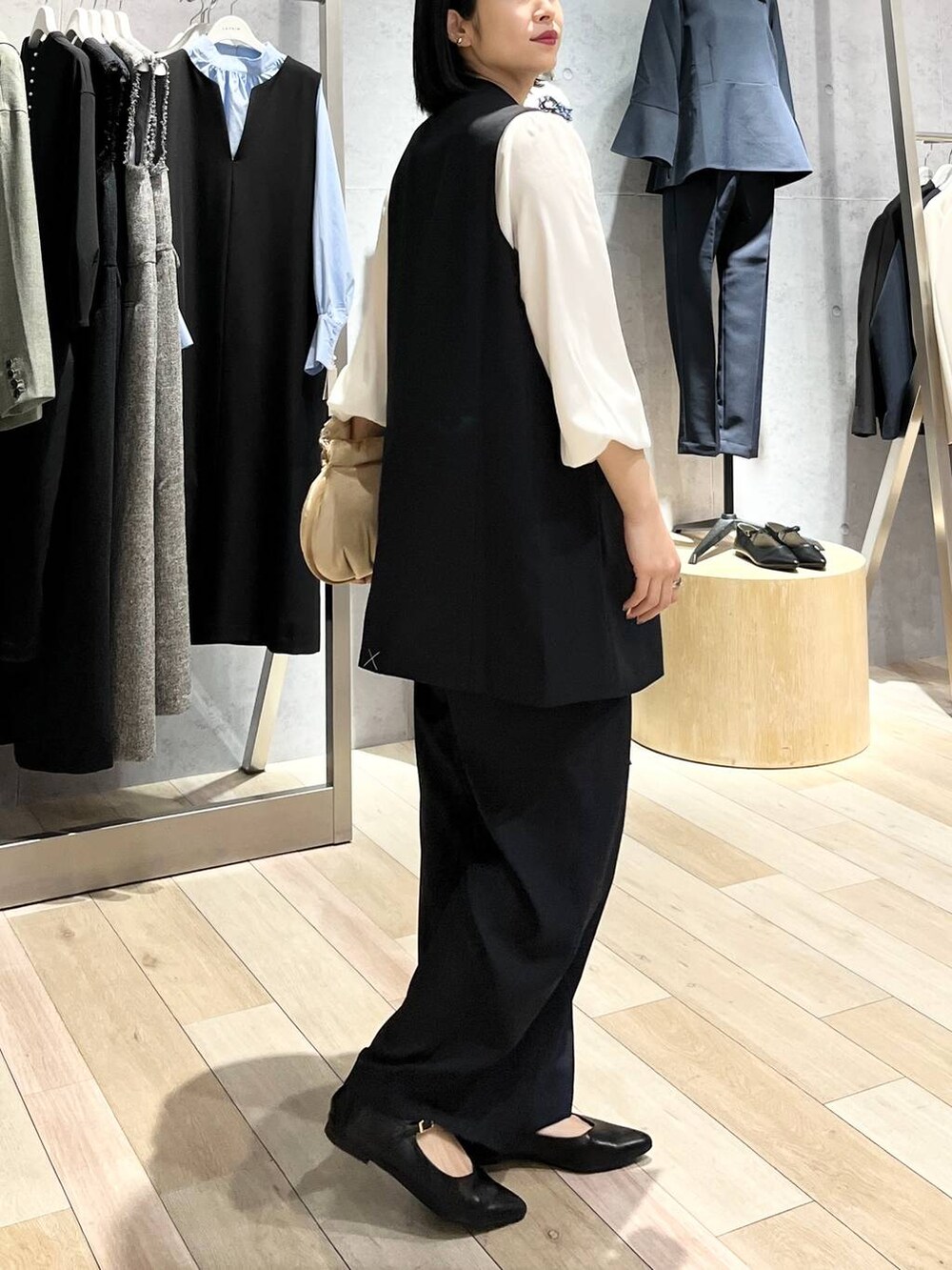 ベージュ系のハンドバッグ、ホワイト系のシャツ/ブラウス、ブラック系のパンプスを着用したレディースの冬コーディネートの4枚目の写真