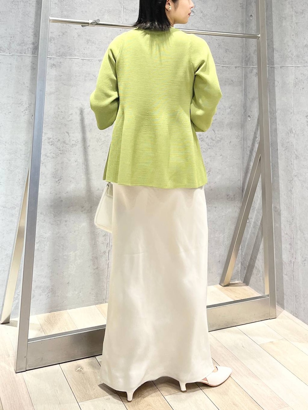ホワイト系のショルダーバッグ、グリーン系のニット/セーター、ホワイト系のスカートを着用したレディースの春コーディネートの6枚目の写真