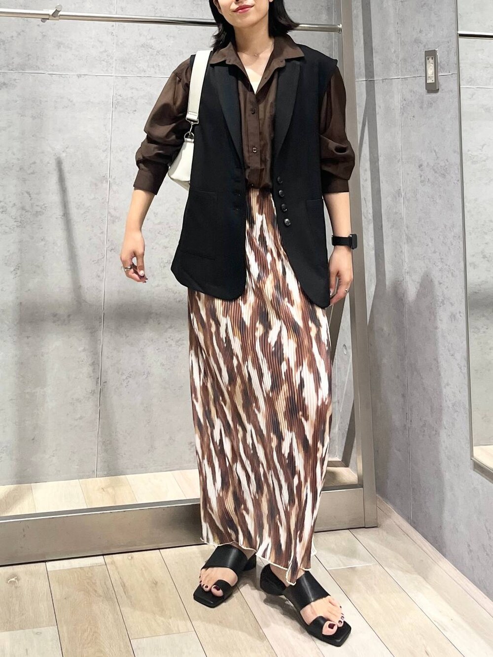 ブラウン系のシャツ/ブラウス、ブラック系のサンダル、グレー系のショルダーバッグを着用したレディースの秋コーディネートの7枚目の写真