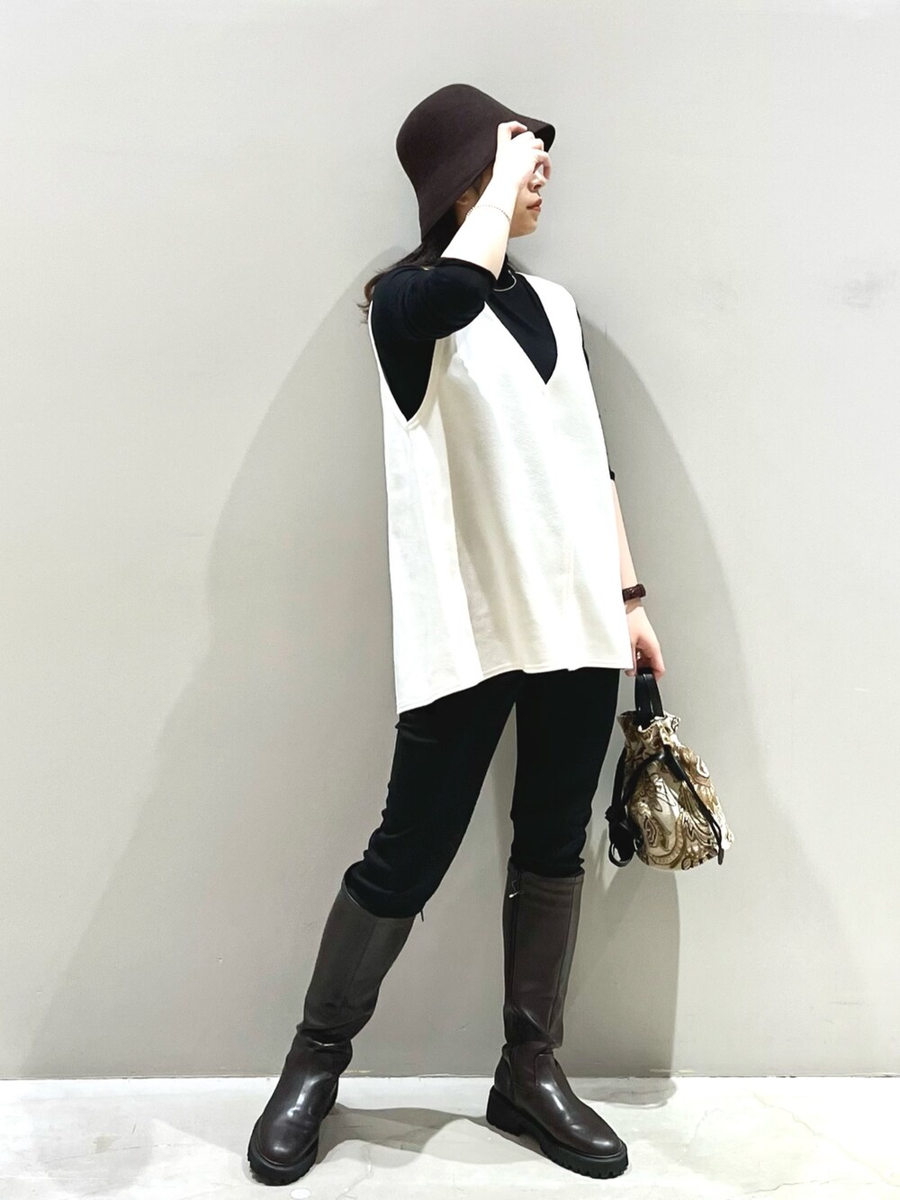 ブラウン系のショルダーバッグ、ブラウン系のブーツ、ブラック系のその他パンツを着用したレディースの秋コーディネートの3枚目の写真