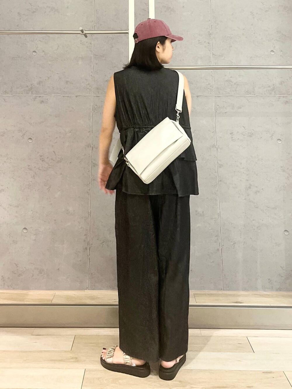 ホワイト系のタンクトップ、ベージュ系のサンダル、ブラック系のつなぎ/オールインワンを着用したレディースの夏コーディネートの5枚目の写真