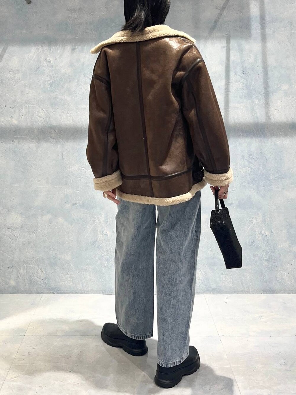 ブラウン系のその他アウター、ブラック系のブーツ、グレー系のニット/セーターを着用したレディースの秋コーディネートの6枚目の写真