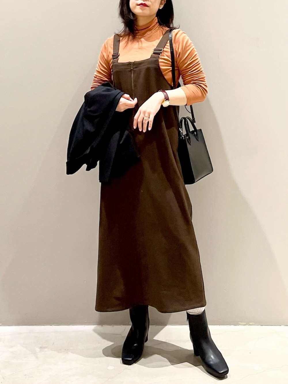 ブラウン系のワンピース、ブラック系のブーツ、ブラウン系のジャケット/アウターを着用したレディースの冬コーディネートの3枚目の写真