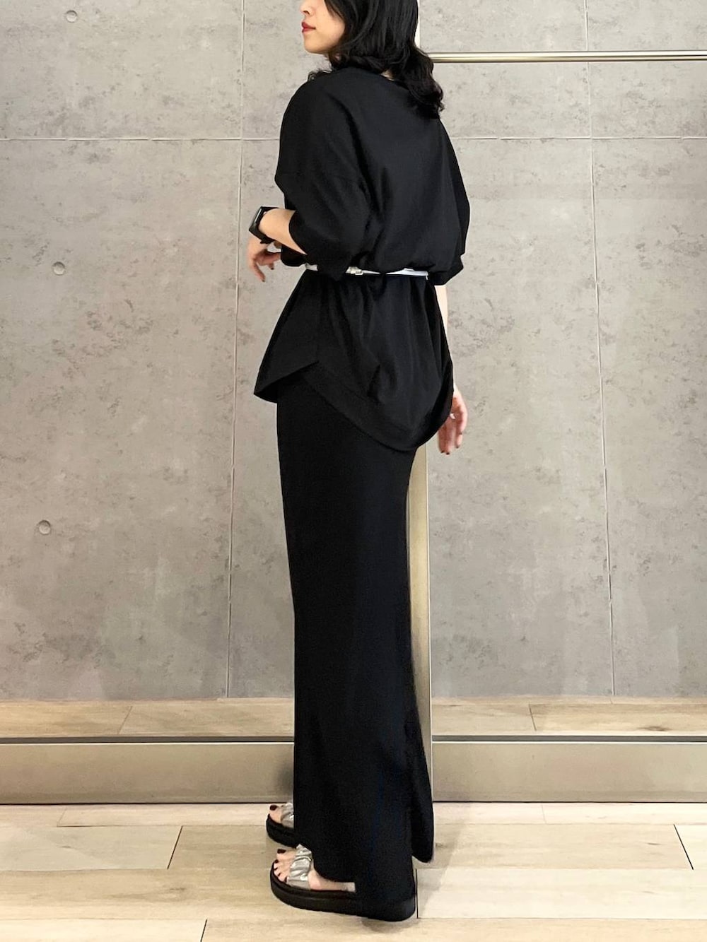 ブラック系のスカート、ブラック系のTシャツ/カットソー、シルバー系のサンダルを着用したレディースの春コーディネートの3枚目の写真