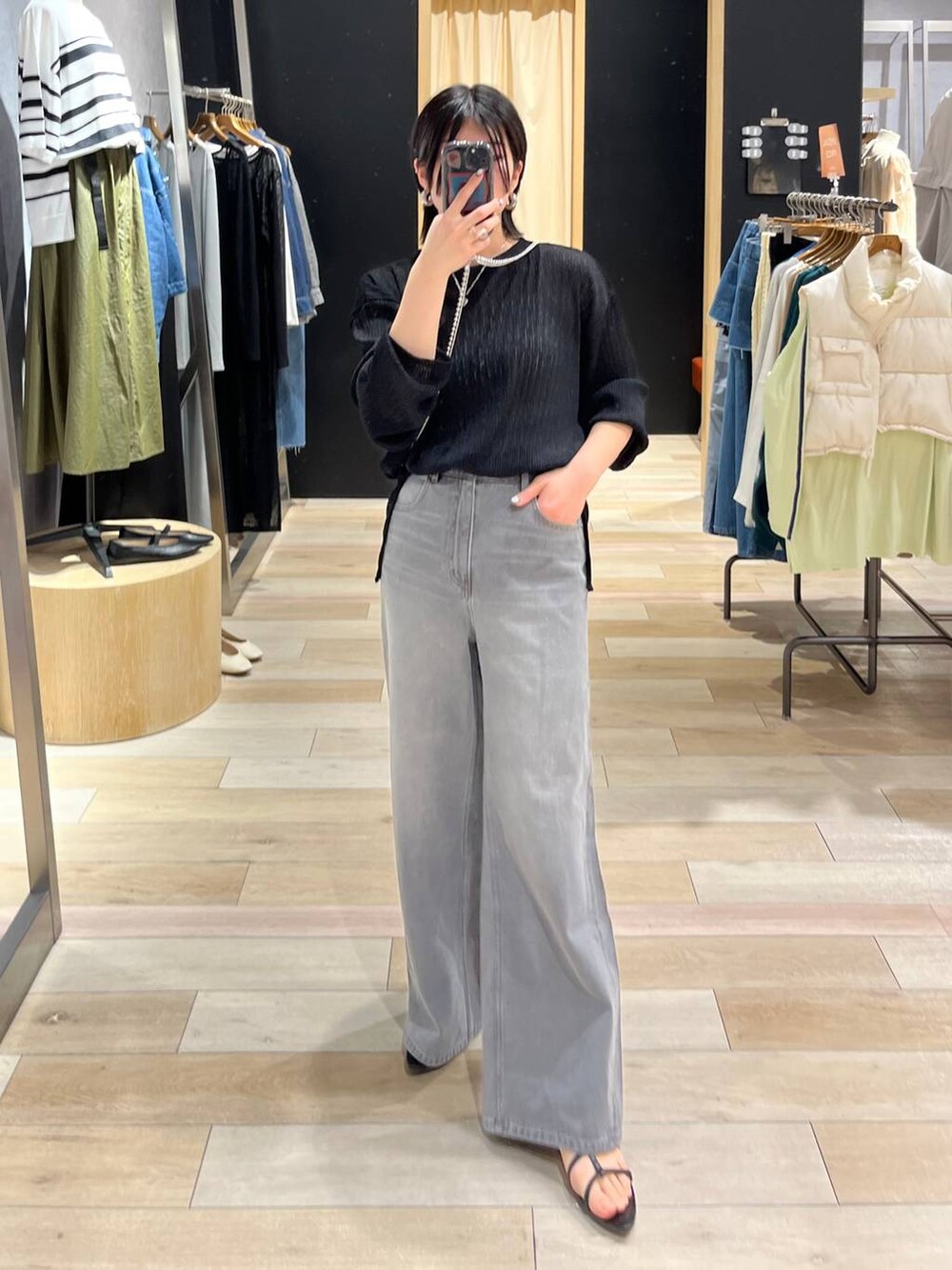 シルバー系のハンドバッグ、ブラック系のサンダル、グレー系のデニムパンツを着用したレディースの春コーディネートの9枚目の写真