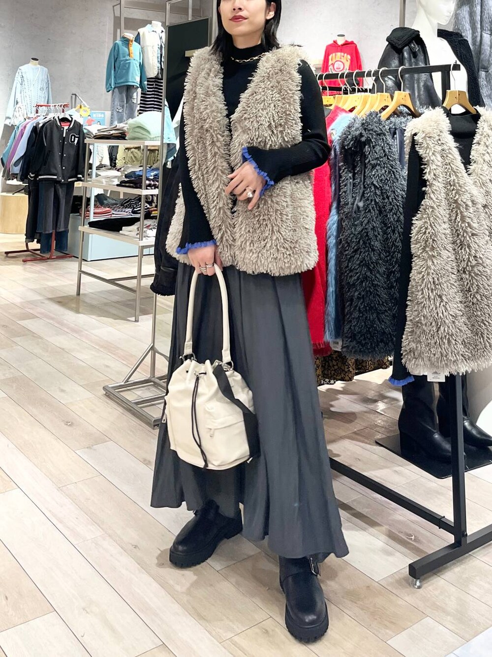 ホワイト系のショルダーバッグ、グレー系のその他パンツ、ブラック系のブーツを着用したレディースの秋コーディネートの2枚目の写真