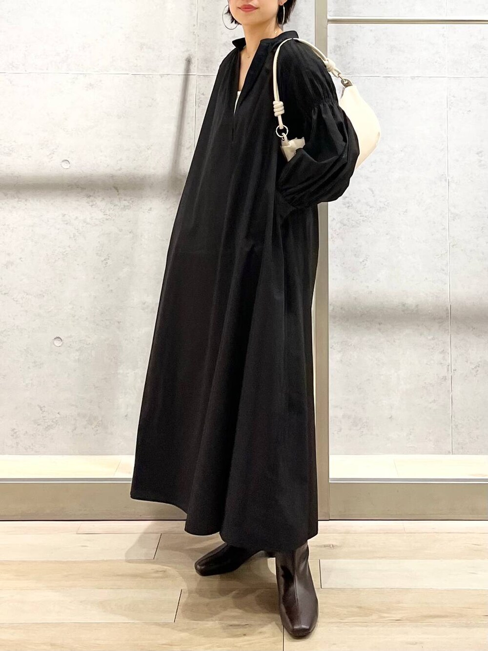 ホワイト系のキャミソール、ブラック系のワンピース、ホワイト系のショルダーバッグを着用したレディースの秋コーディネートの2枚目の写真