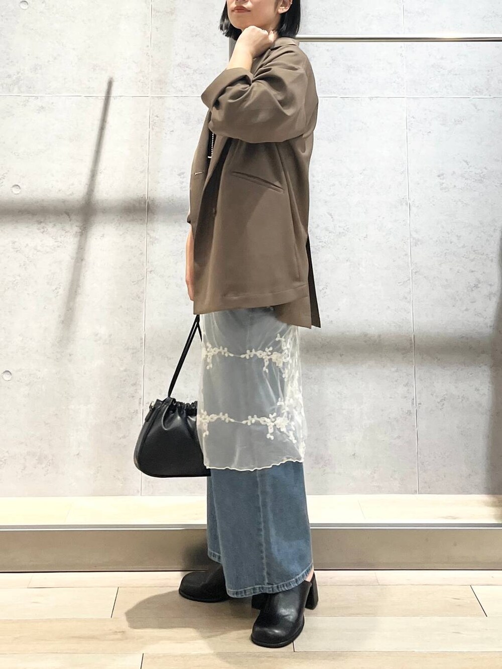 ブルー系のデニムパンツ、ブラック系のその他シューズ、ブラック系のショルダーバッグを着用したレディースの秋コーディネートの2枚目の写真