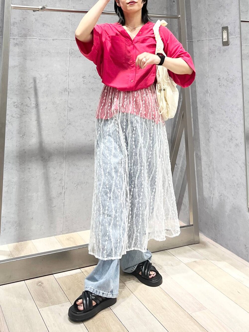 ブラック系のサンダル、ブルー系のデニムパンツ、ホワイト系のスカートを着用したレディースの夏コーディネートの6枚目の写真