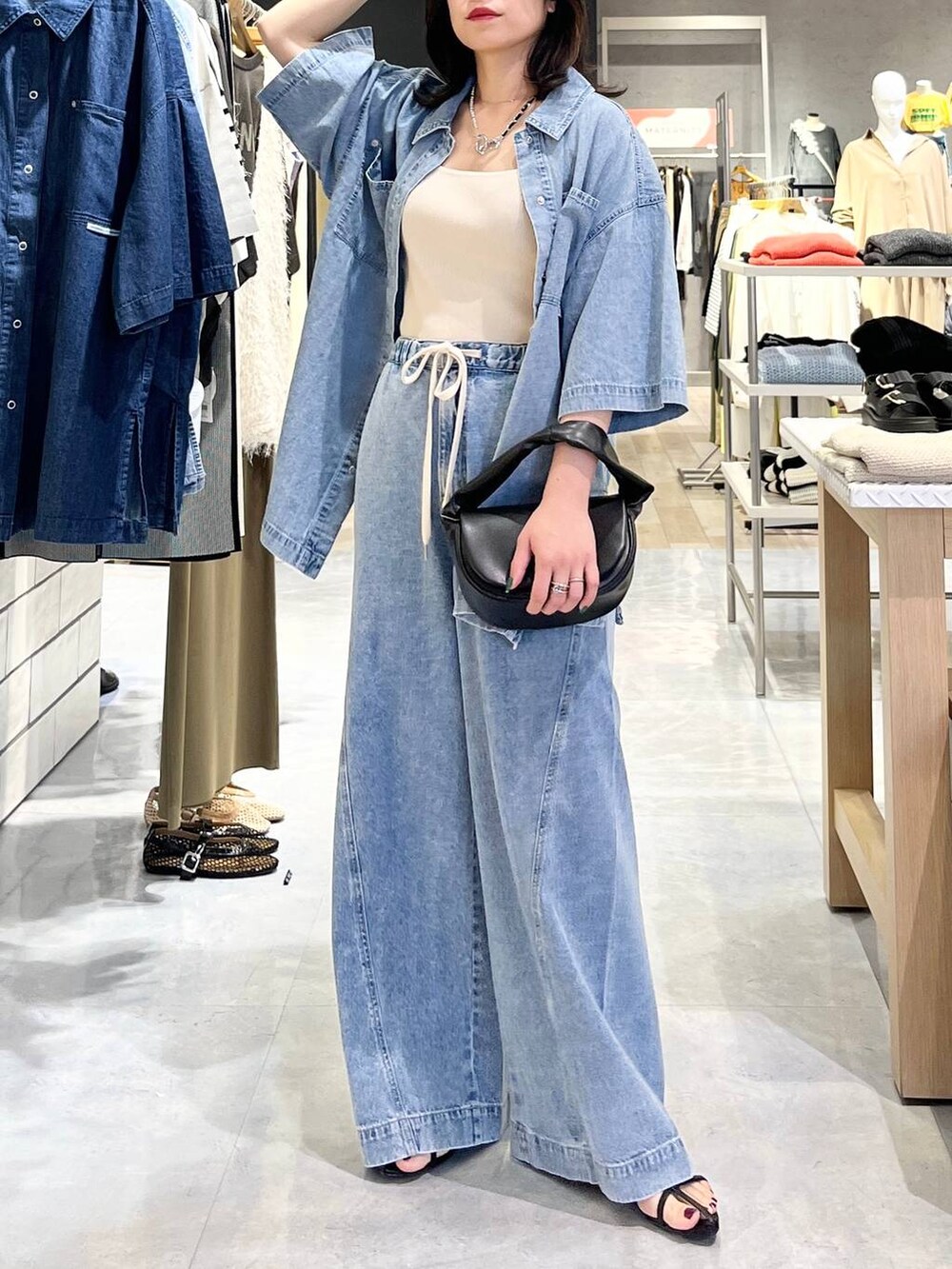 ブルー系のシャツ/ブラウス、ホワイト系のタンクトップ、ブルー系のデニムパンツを着用したレディースの春コーディネートの2枚目の写真