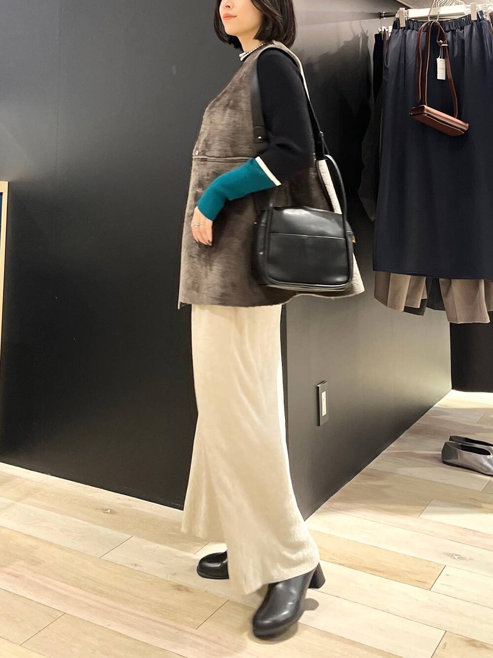 ブラック系のニット/セーター、ブラック系のブーツ、ブラック系のショルダーバッグを着用したレディースの秋コーディネートの3枚目の写真