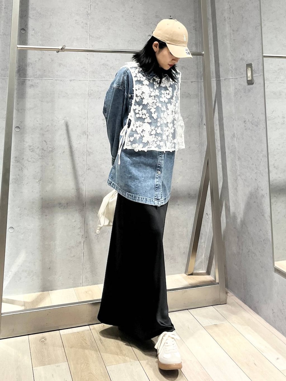 ブラック系のスカート、ブルー系のシャツ/ブラウス、ホワイト系のスニーカーを着用したレディースの冬コーディネートの4枚目の写真