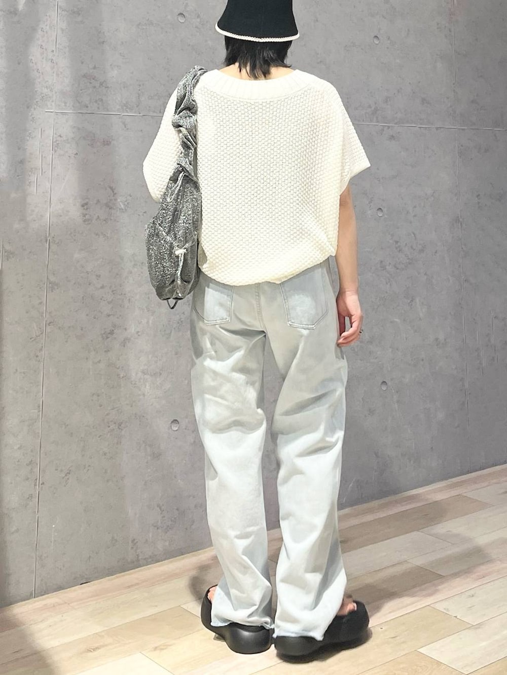 ブラック系のサンダル、ブルー系のデニムパンツ、ホワイト系のニット/セーターを着用したレディースの夏コーディネートの4枚目の写真