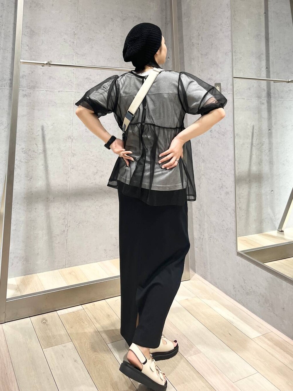 ブルー系のショルダーバッグ、ブラック系のスカート、ホワイト系のサンダルを着用したレディースの春コーディネートの4枚目の写真