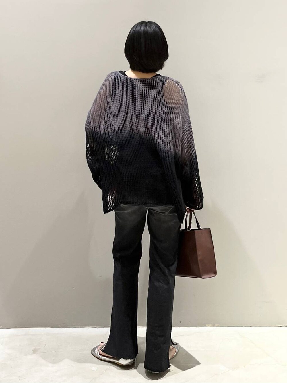 ブラック系のニット/セーター、シルバー系のサンダル、ブラック系のデニムパンツを着用したレディースの夏コーディネートの7枚目の写真