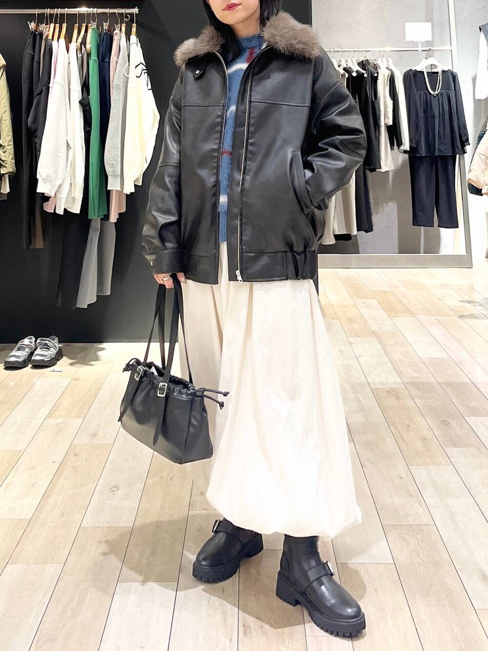 ブラック系のTシャツ/カットソー、ブラック系のブーツ、ブラック系のショルダーバッグを着用したレディースの冬コーディネートの2枚目の写真