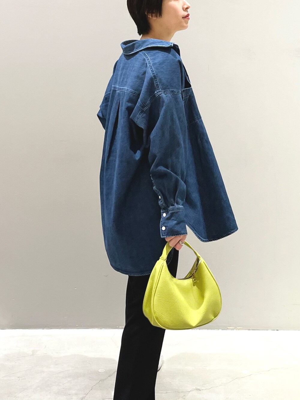 イエロー系のショルダーバッグ、ブラック系のその他パンツ、グレー系のパンプスを着用したレディースの春コーディネートの6枚目の写真