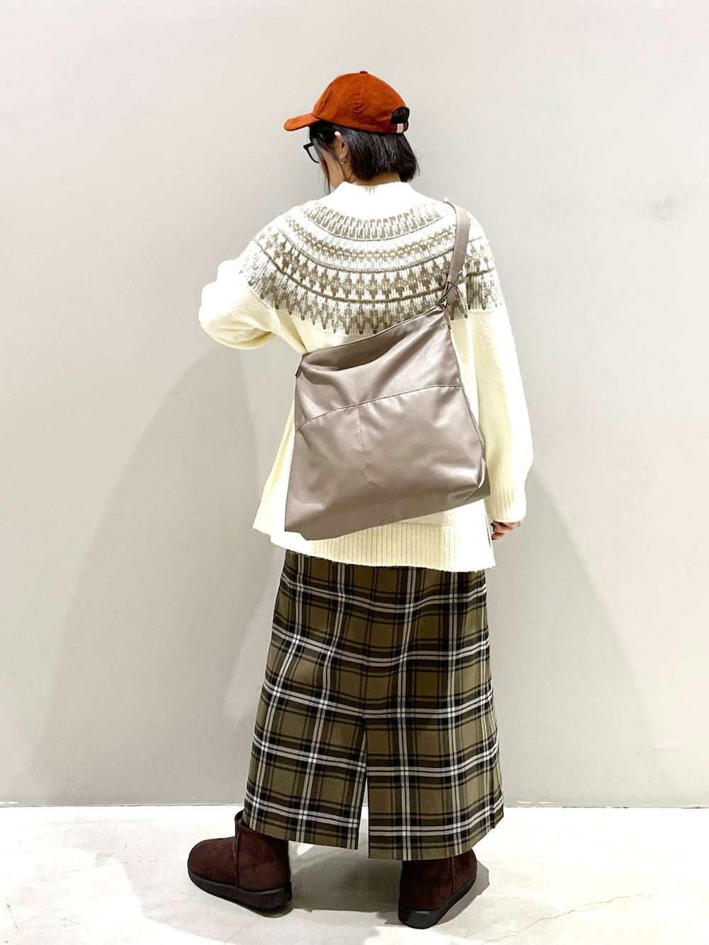 ブラウン系のスカート、ブラウン系のブーツ、ベージュ系のショルダーバッグを着用したレディースの冬コーディネートの3枚目の写真