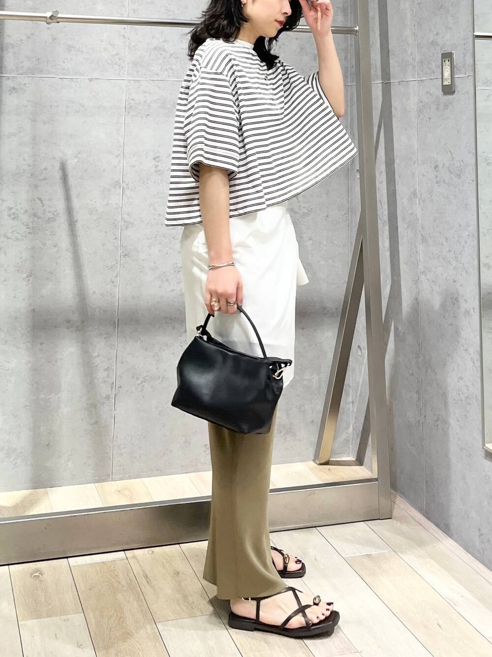 グリーン系のスカート、ホワイト系のTシャツ/カットソー、ホワイト系のシャツ/ブラウスを着用したレディースの春コーディネートの3枚目の写真