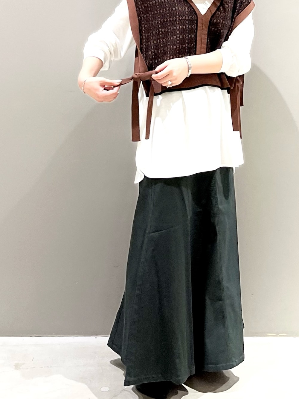 グレー系のスカート、ブラック系のパンプス、ブラウン系のマタニティウェア/グッズを着用したレディースの秋コーディネートの3枚目の写真