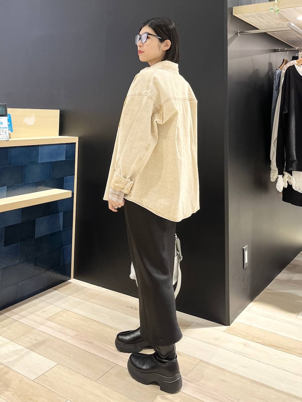 ブラック系のTシャツ/カットソー、ブラック系のスカート、ブラック系のブーツを着用したレディースの春コーディネートの4枚目の写真