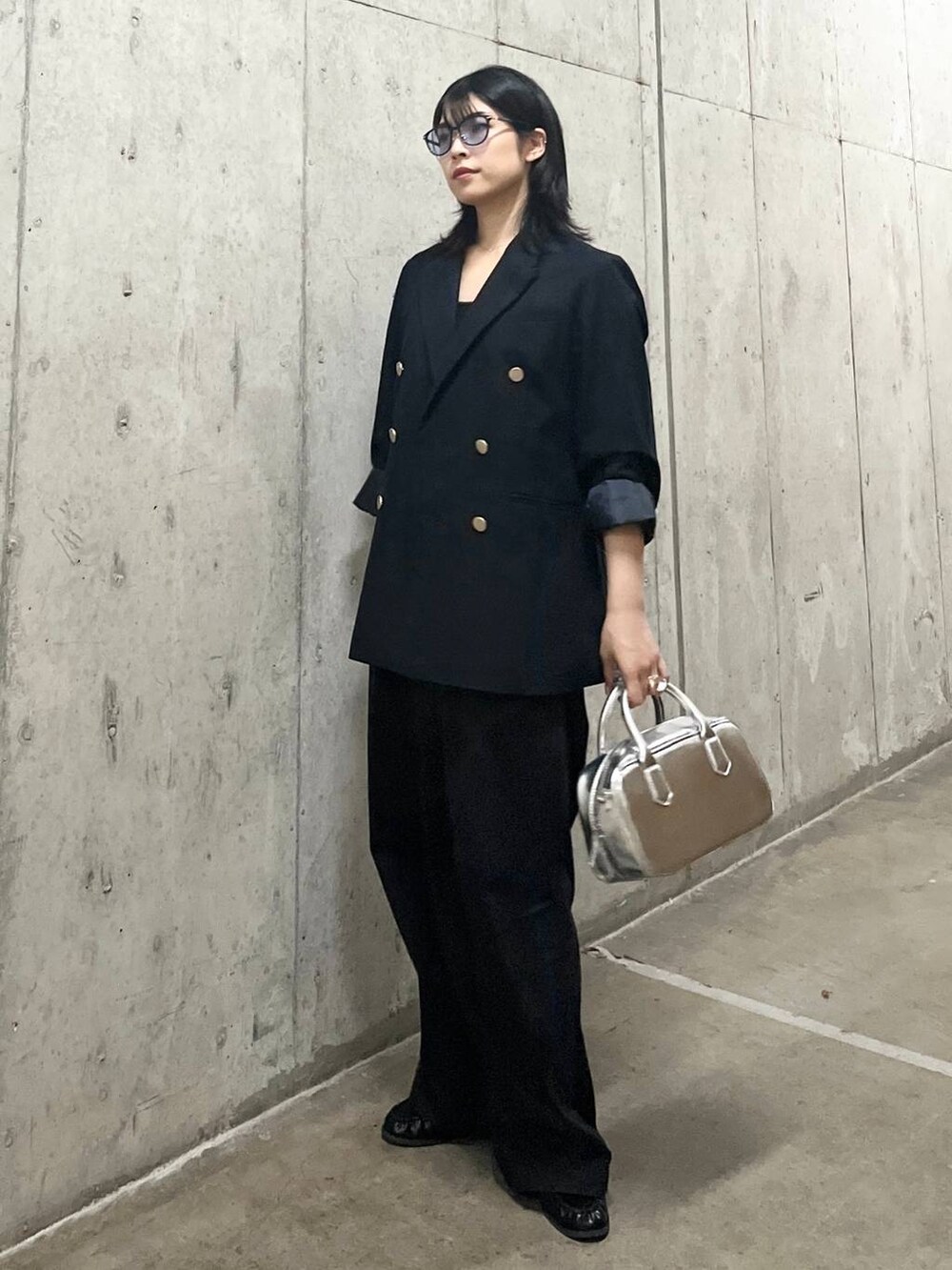 ブルー系のテーラードジャケット、シルバー系のボストンバッグ、グレー系のチノパンツを着用したレディースの秋コーディネートの7枚目の写真