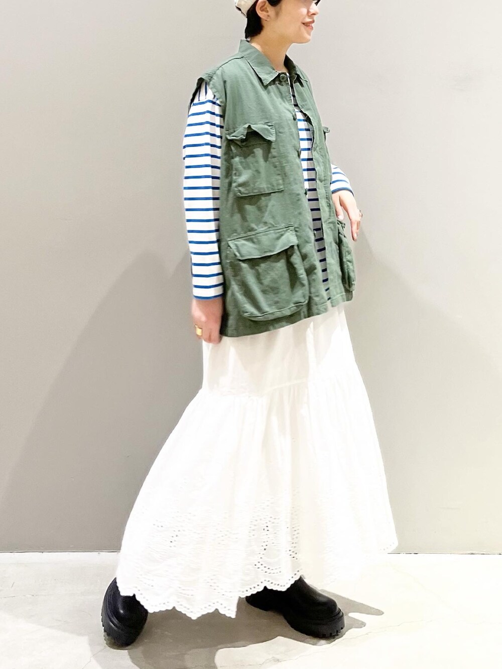 ブラック系のブーツ、ブルー系のTシャツ/カットソー、グリーン系のベストを着用したレディースの春コーディネートの4枚目の写真