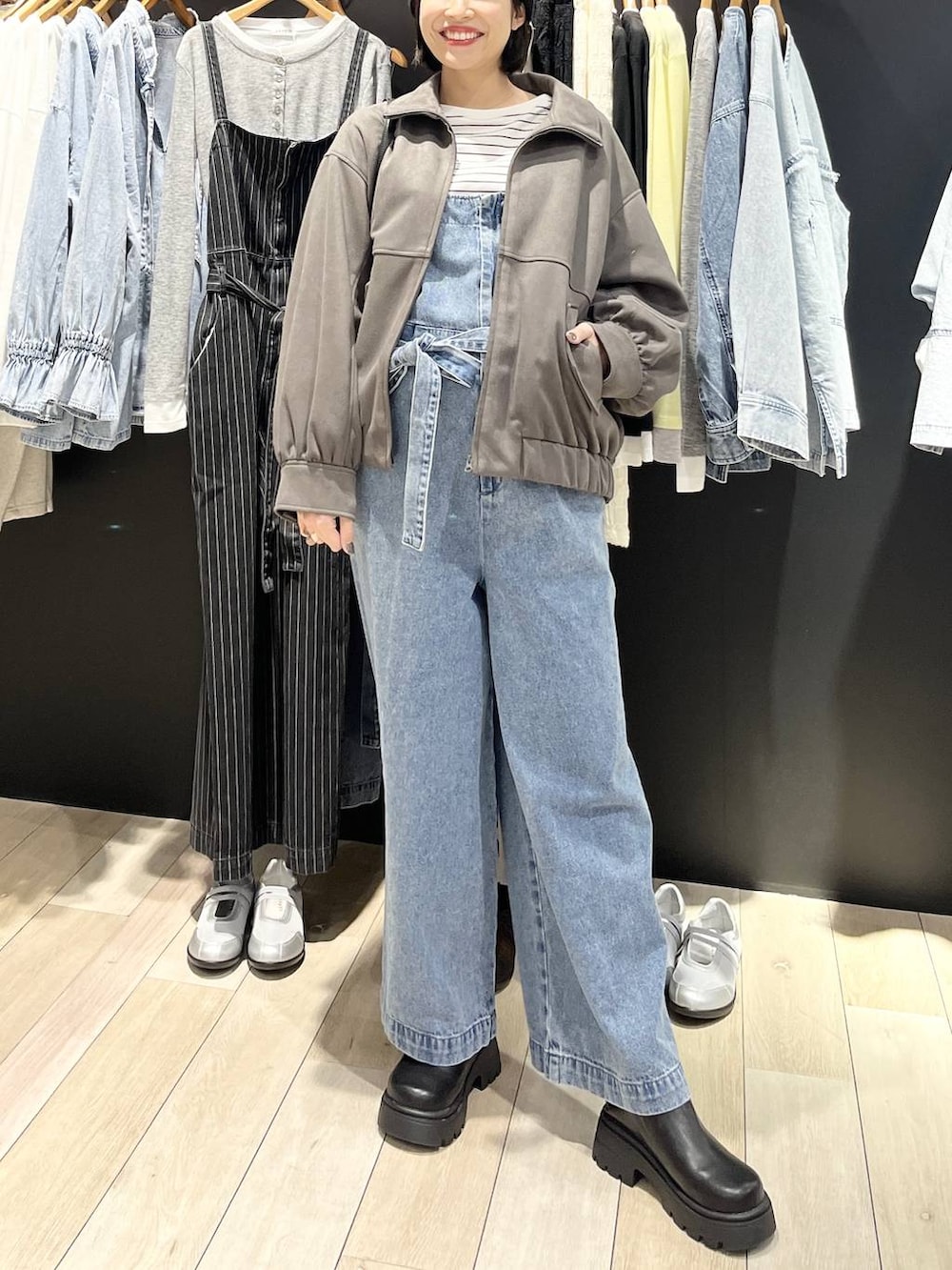 ブラック系のボストンバッグ、ブラック系のブーツ、ブルー系のサロペット/オーバーオールを着用したレディースの冬コーディネートの2枚目の写真