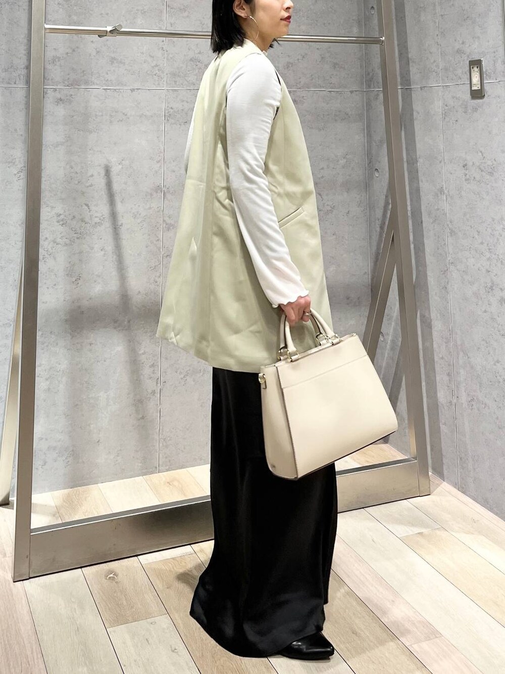 ホワイト系のTシャツ/カットソー、ブラック系のスカート、ホワイト系のショルダーバッグを着用したレディースの冬コーディネートの3枚目の写真