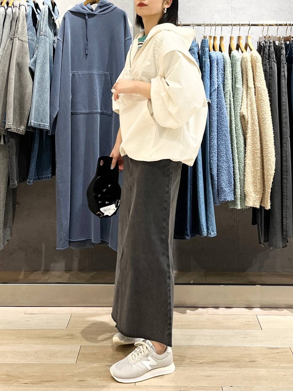 ブラック系のショルダーバッグ、ホワイト系のTシャツ/カットソー、ブラック系のスカートを着用したレディースの春コーディネートの6枚目の写真