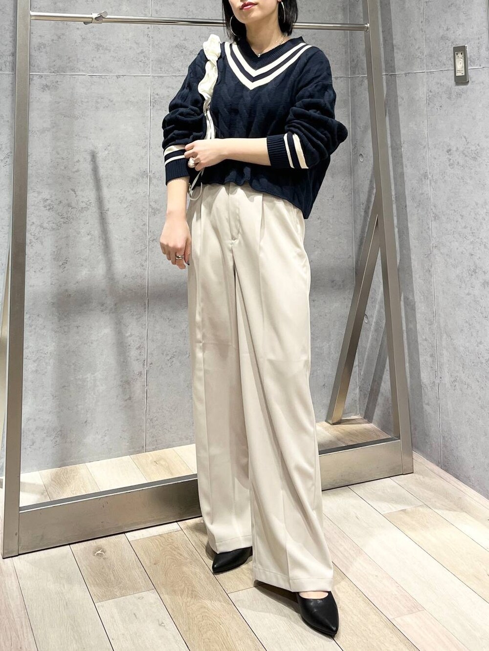 ブルー系のニット/セーター、ホワイト系のショルダーバッグ、ブラック系のパンプスを着用したレディースの冬コーディネートの2枚目の写真