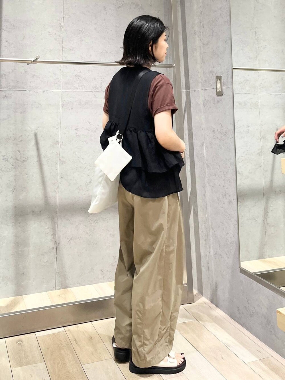 ホワイト系のサンダル、ブラック系のベスト、ブラウン系のTシャツ/カットソーを着用したレディースの夏コーディネートの6枚目の写真