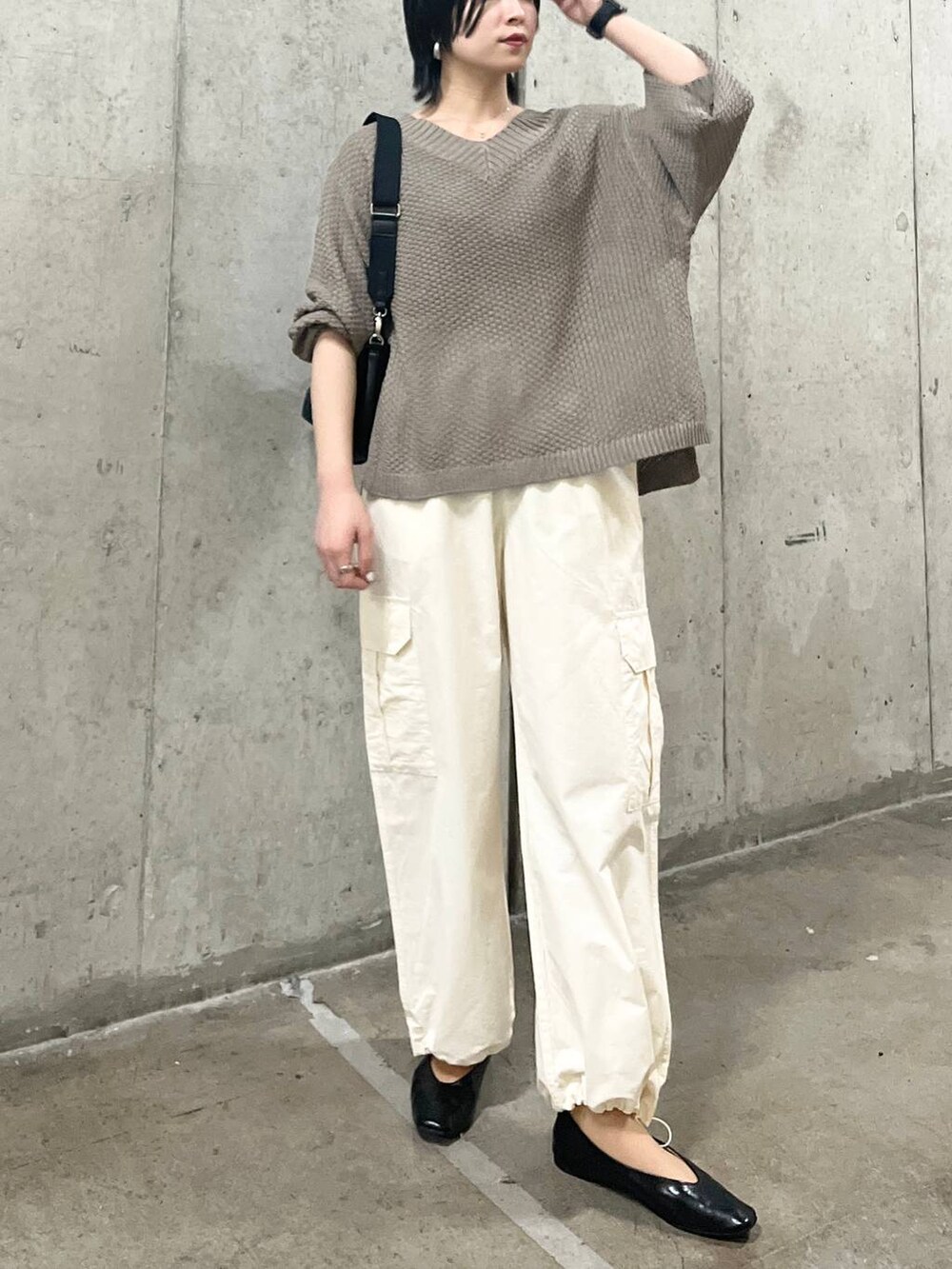 ブラック系のショルダーバッグ、ホワイト系のカーゴパンツ、ブラック系のパンプスを着用したレディースの春コーディネートの3枚目の写真