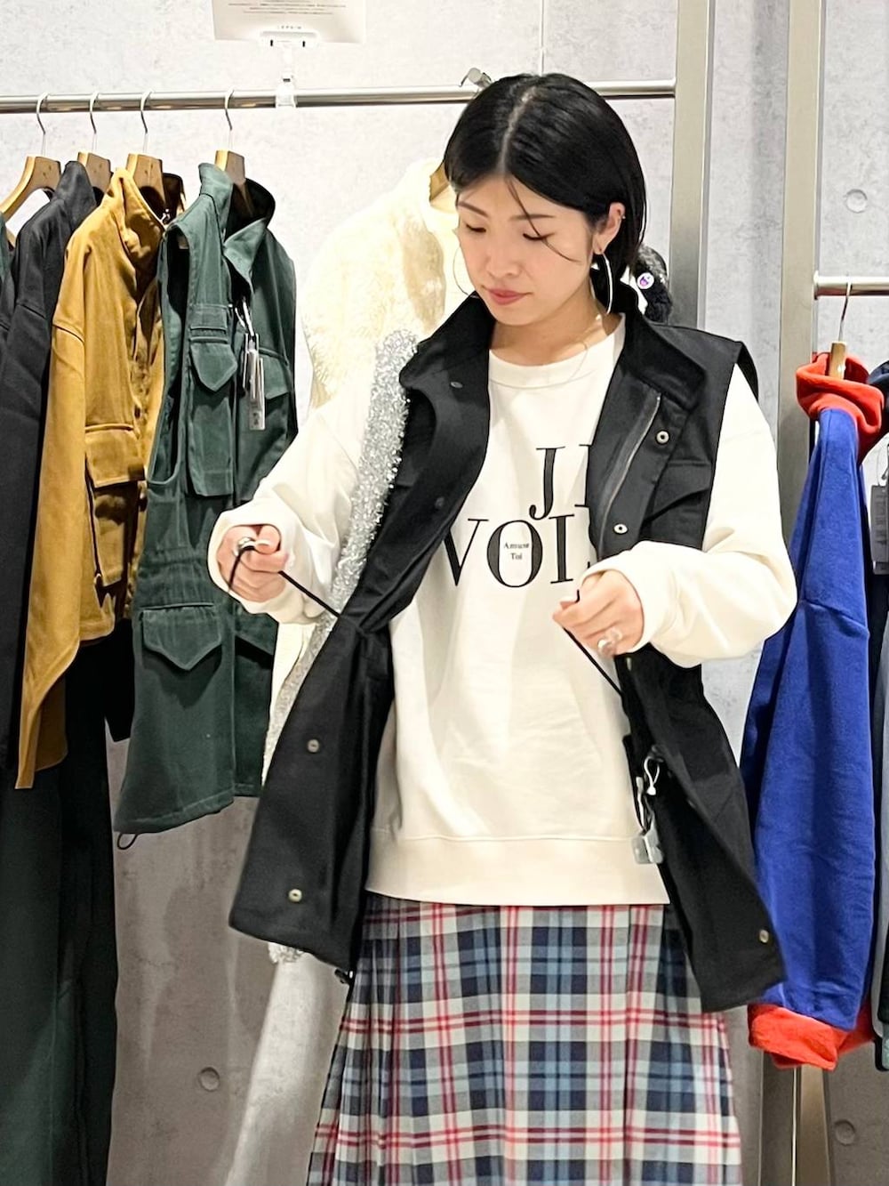 ブラック系のベスト、ホワイト系のスウェット、ブラック系のブーツを着用したレディースの秋コーディネートの6枚目の写真