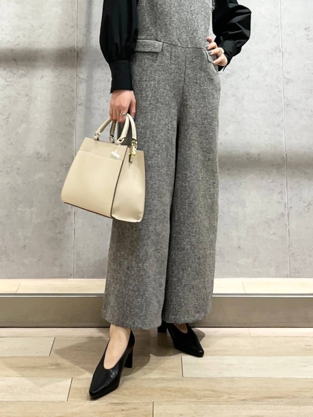 ブラック系のパンプス、ホワイト系のサロペット/オーバーオール、ブラック系のシャツ/ブラウスを着用したレディースの冬コーディネートの3枚目の写真